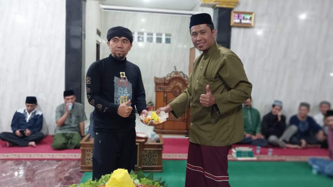 Seksi Rohani RW 16 Ustadz Rohmat bersama Ketua RT 01 Dede Taryana usai proses potong tumpeng di Masjid Darul Muqomah